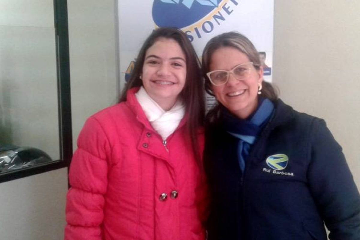 Valentina com a professora Graciele, em visita à redação. Foto: Alex Tomilin/Rádio Missioneira