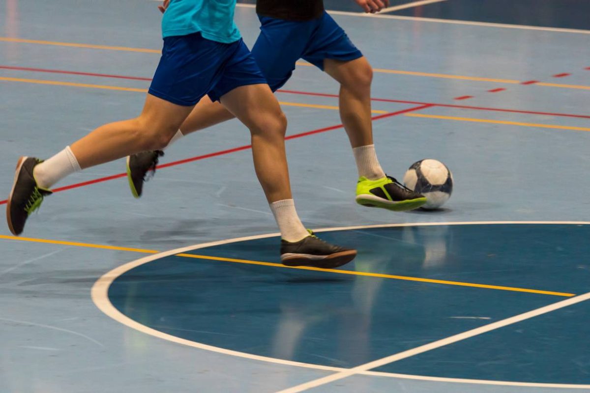 Futsal player with the ball in the sports hall